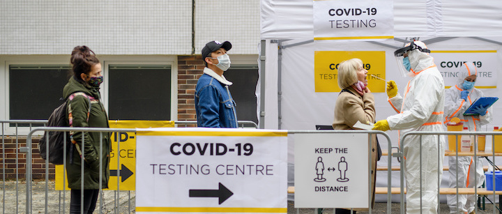 people wait in line for COVID-19 testing